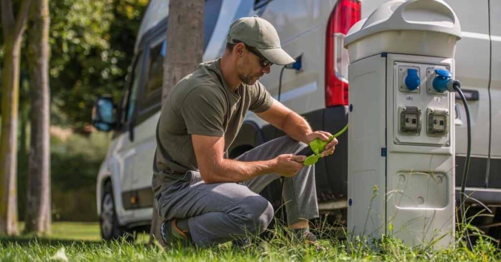 Man connect RV to pedestal at RV campground