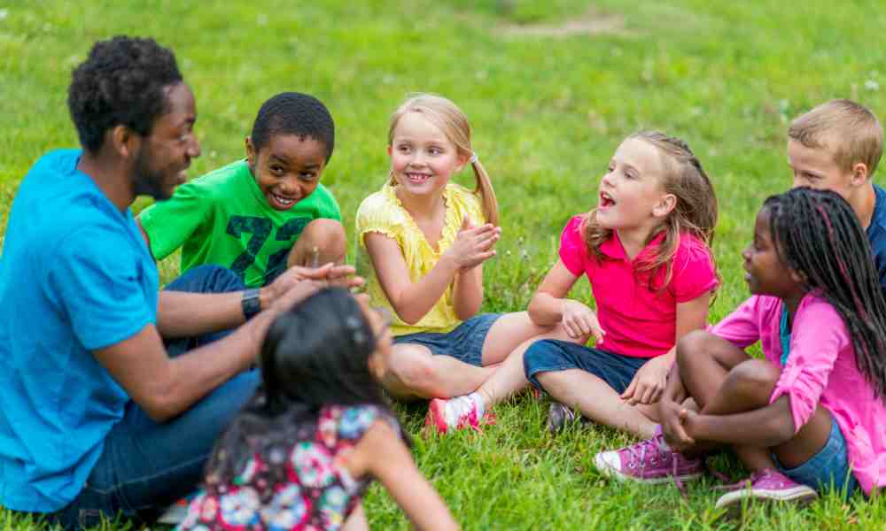 Kids sitting in the grass having fun