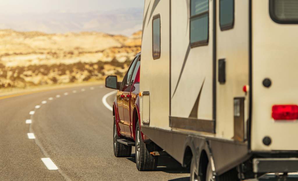 Red trucking towing a travel trailer