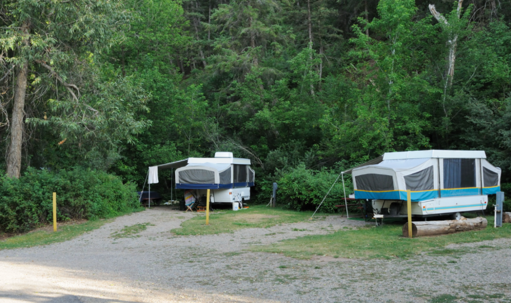 two pop-up campers at a campground